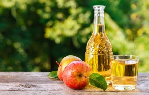 Apple Cider Vinegar bottle and 2 apples with garden background | What Is Apple Cider Vinegar? | Can Apple Cider Vinegar Help Treat Erectile Dysfunction?