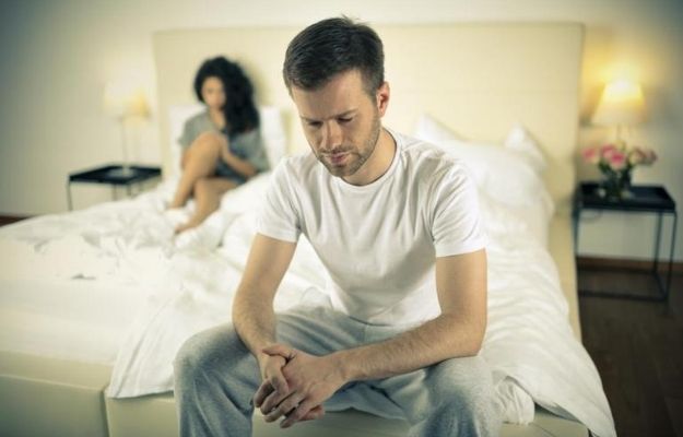 anxious man sat on the end of the bed and a woman sat behind him | What Are The Other Ways To Cure Erectile Dysfunction? | Can Apple Cider Vinegar Help Treat Erectile Dysfunction?
