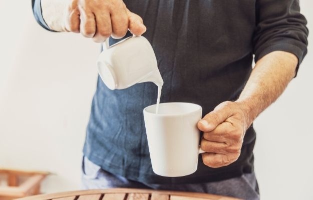 man is pouring milk in white cup | Benefits of Spermidine for Cell Renewal