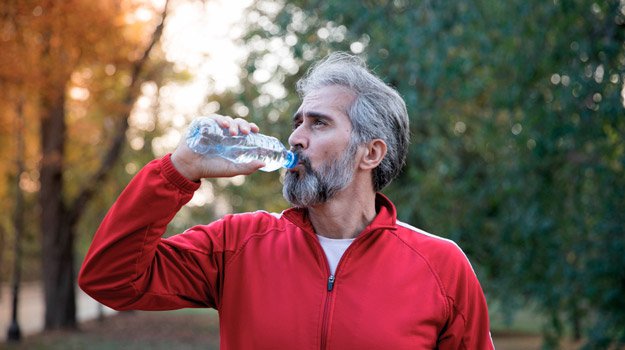 Post-workout Nutrition: What Should I Eat After Exercise? | mature-man-drinking-water-after-workout-in-outdoor-autumn-scenery-ss | Don't Forget to Drink Plenty of Water