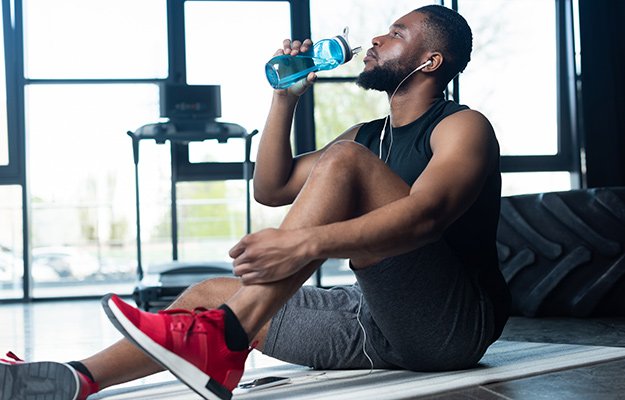 A man doing exercise drinking water | 12 Interesting Reasons You Need To Drink More Water