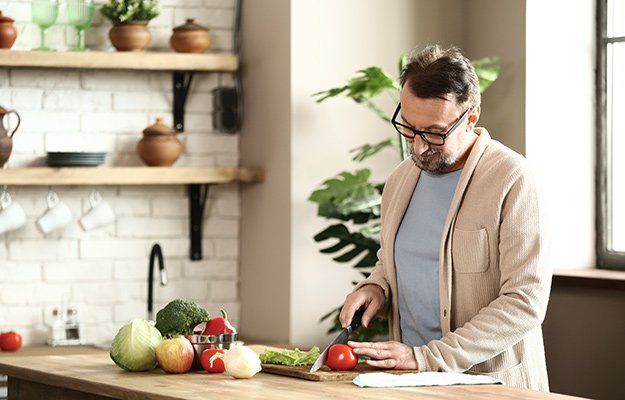 A middle-aged man cooking the healthy homemade meal | What Are Nootropics? ‘Cognitive Enhancers’ to Increase Mental Alertness