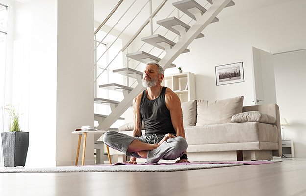A strong middle aged man doing yoga at home | How A Strong Immune System Could Be The Best Response To COVID-19 & Its Variants