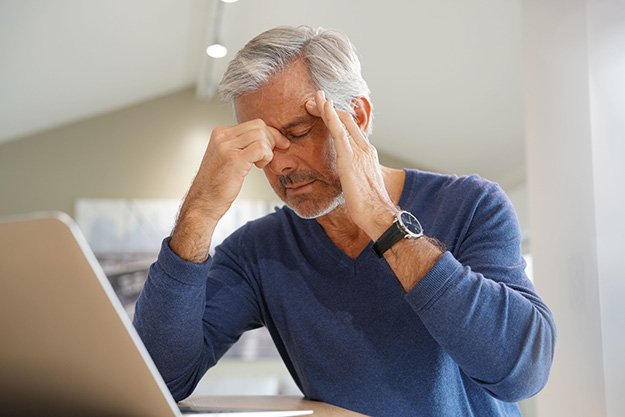 Senior-man-having-a-headache-while-working-on-laptop-computer-Loss-of-Muscle-Mass-ss-body | 12 Signs That You Need a Testosterone Test