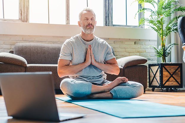 middle aged sport man doing yoga_How To Lower Cortisol | 15 Signs That Your Cortisol Levels Are Too High