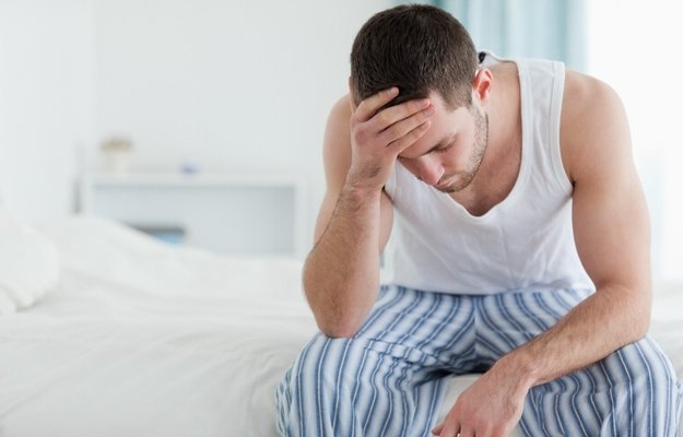 A tired and stressful man sitting on the bed_ss | What Causes Low Libido in Men and How to Treat It