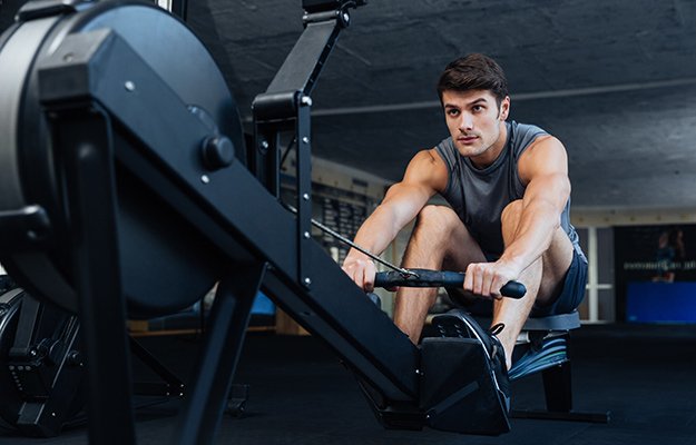 Man using rowing machine in the gym | Low Impact Exercises That Keep You Fit