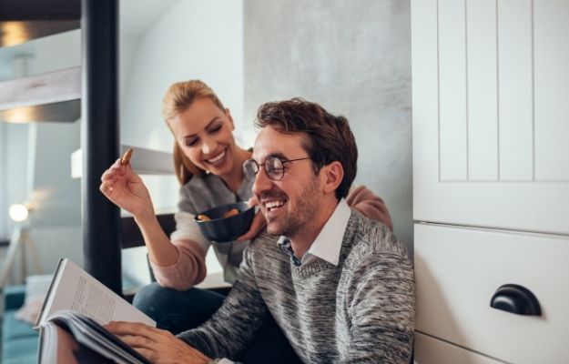 a happy man reading book and sitting next to a woman | Daily Strategies To Perform On Top Of Your Game