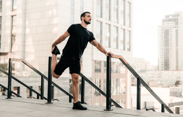 man-stretching-legs-before-workout-outdoors | HOW TO GET MORE ENERGY | EXERCISE,-BREATHE,-SWEAT