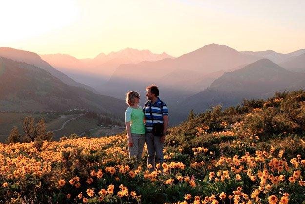 Mature couple holding each other in flowery outdoor scenery overcoming intimacy issues