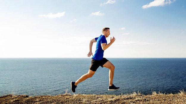 Mature man running under sun sea side