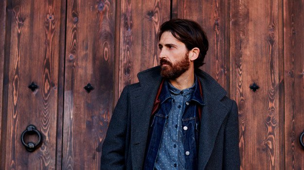 middle-aged-bearded-man-with-luscious-hair-portrait-in-front-of-wooden-wall | First Signs of Hair Loss And What To Do