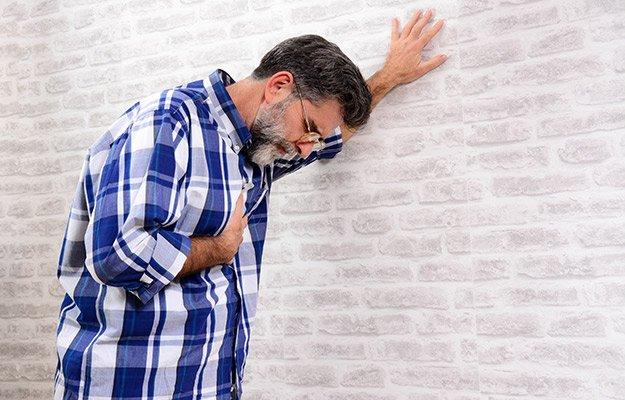 senior man trying to standing due to heart attack | Is Sleeping In Bad For Your Sleep Routine or Health