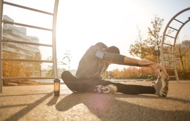 sportsman stretching on sport ground