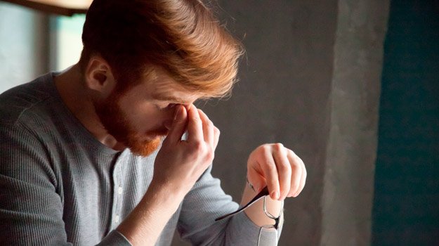 Young ginger man feeling stressed tired