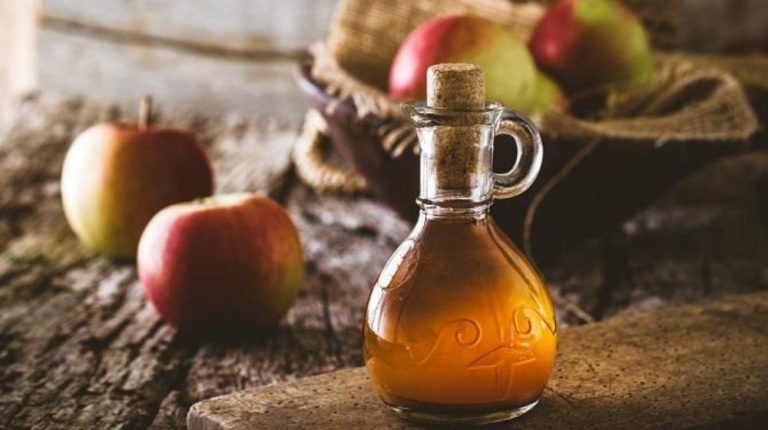 Apple Cider Vinegar bottle with apples in the background | Feature | Can Apple Cider Vinegar Help Treat Erectile Dysfunction?