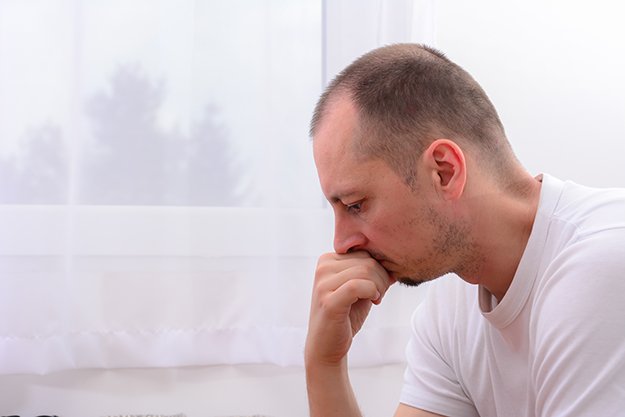 depressed-man-near-window-at-home-Performance-Anxiety | Performance Anxiety ED: How to Overcome Fear Of Sex