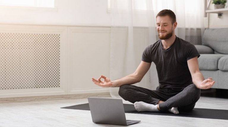 a guy meditating with trainer online via laptop connection | Feature | When Is The Best Time To Meditate For Optimized Health?