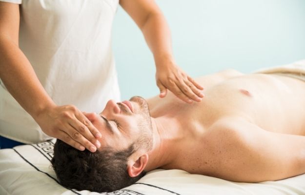therapist using her hands for some holistic therapy on a man | Why is a Holistic Approach to Health Important? | Why A Holistic Approach to Health is Important
