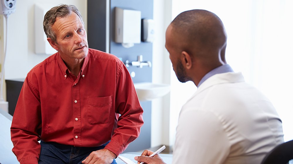 Male-patient-and-doctor-having-consultation-in-hospital-room-ss-feat | 9 Preventive Health Screening Tests For Men
